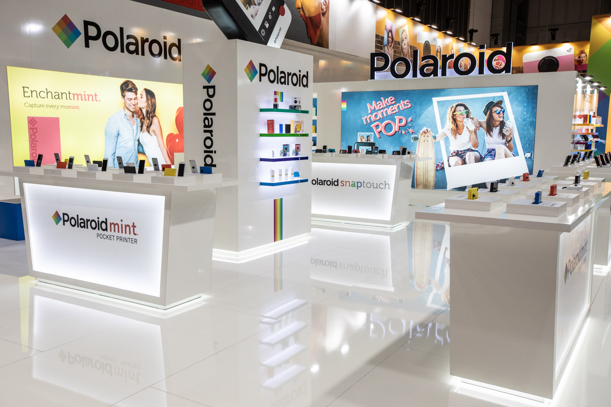 Polaroid at IFA Berlin 2018 — Stand design White Polaroid exhibition stand with product counters and illuminated displays at IFA Berlin 2018